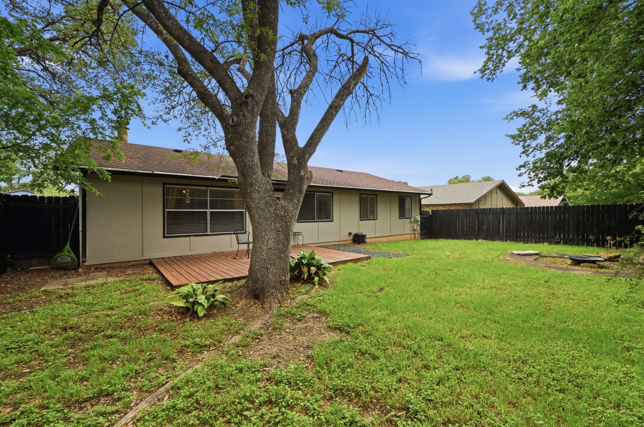 6805 Rearden Road Austin, TX 78745 - Photo 23 of 26 A spacious yard boasts a wooden deck and ample green space, ideal for outdoor enjoyment.