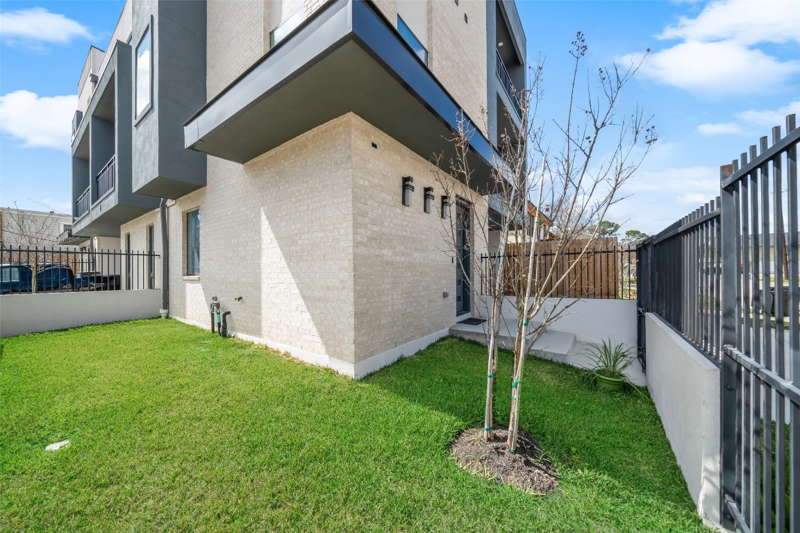 Fenced yard featuring a well-maintained lawn.