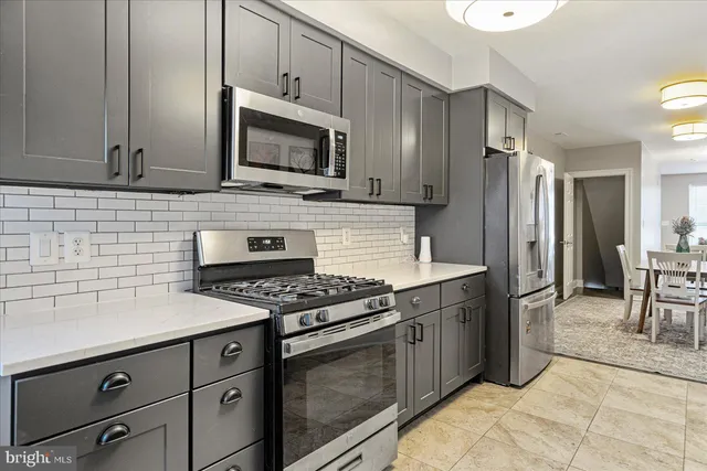 a kitchen with stainless steel appliances granite countertop a stove a microwave and a refrigerator