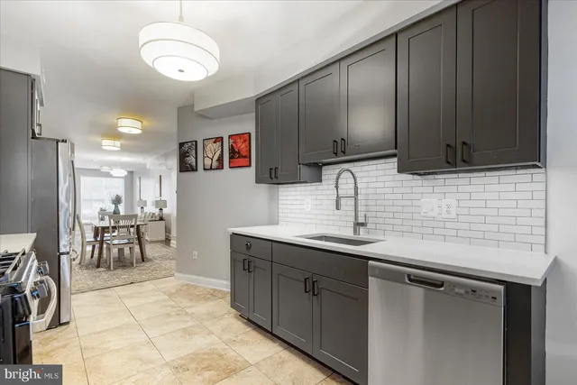 a kitchen with stainless steel appliances a sink stove and cabinets