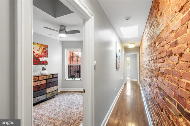 a view of a hallway with wooden floor and furniture