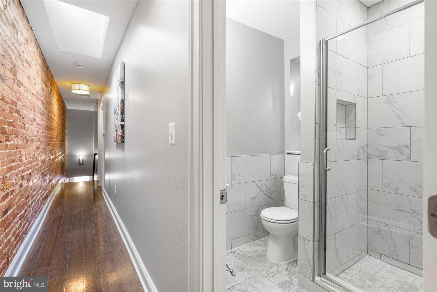 2428 McCulloh Street Baltimore, MD 21217 - Photo 27 of 42 a bathroom with a glass door shower a toilet and a sink