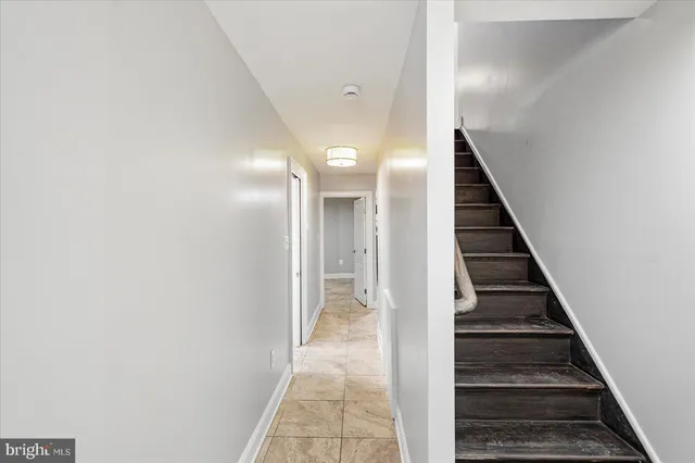 a view of a hallway with wooden floor and stairs