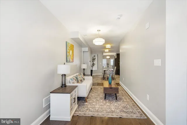 a living room with couches and painting on the wall