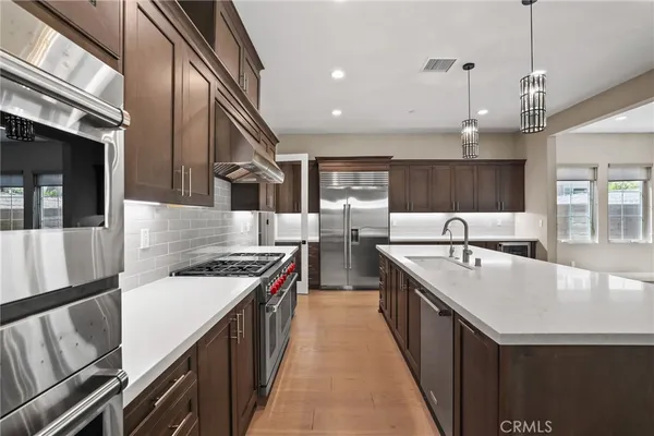 a kitchen with stainless steel appliances granite countertop a sink and a stove