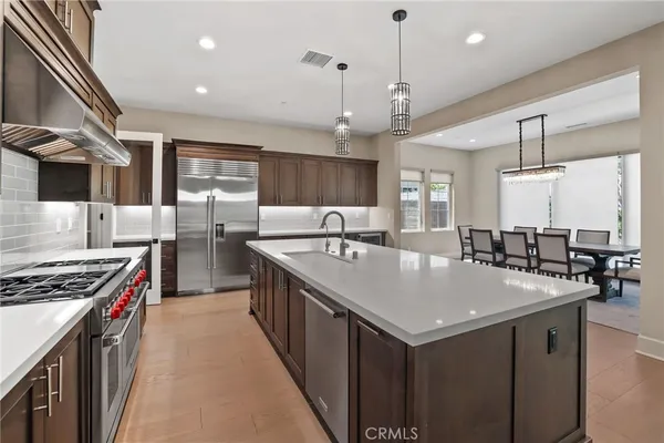 a kitchen with stainless steel appliances granite countertop a sink a stove and a wooden floors