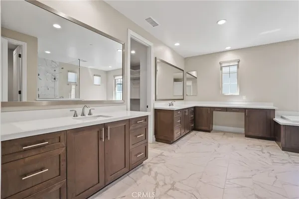 a large kitchen with a large counter top sink and stainless steel appliances