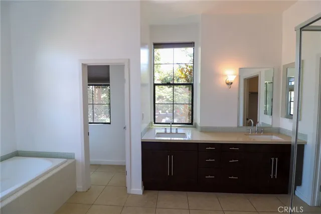 a bathroom with a tub sink and mirror
