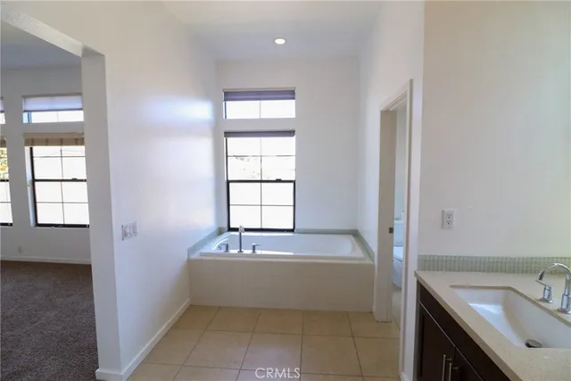 a bathroom with a bathtub sink and mirror