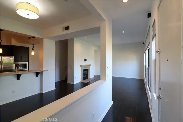 a view of a hallway with wooden floor and a living room