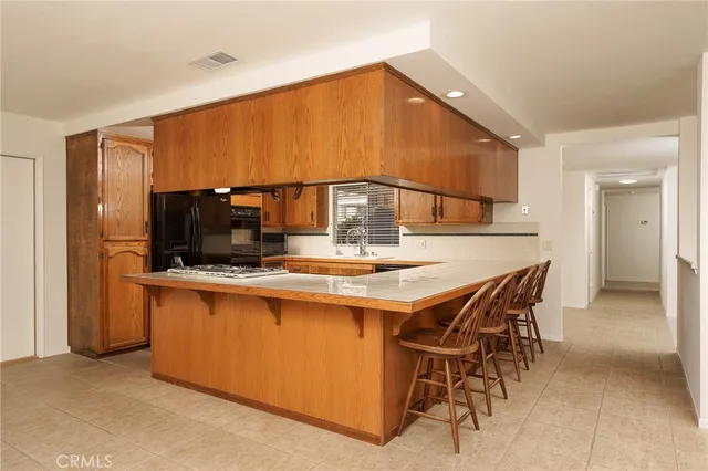 a kitchen with stainless steel appliances granite countertop a table chairs and stove