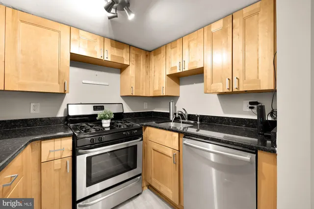 a kitchen with granite countertop cabinets stainless steel appliances and a window