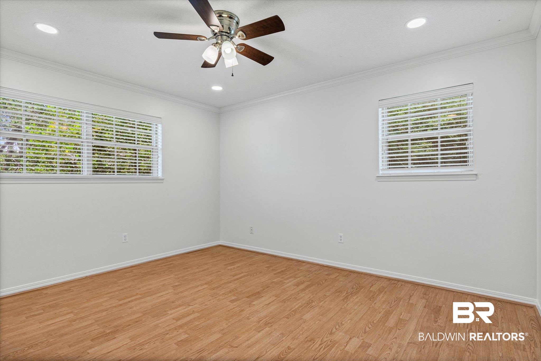 8301 Fordham Road Mobile, AL 36619 - Photo 17 of 57 Bright room featuring wood-finish flooring, two windows with blinds, a ceiling fan with integrated lighting, and recessed lighting