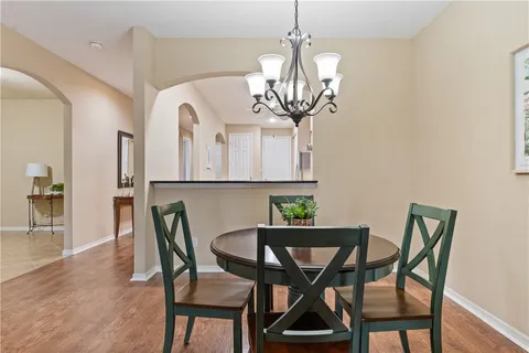 a view of a dining room with furniture a chandelier and wooden floor