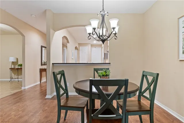 a view of a dining room with furniture a chandelier and wooden floor