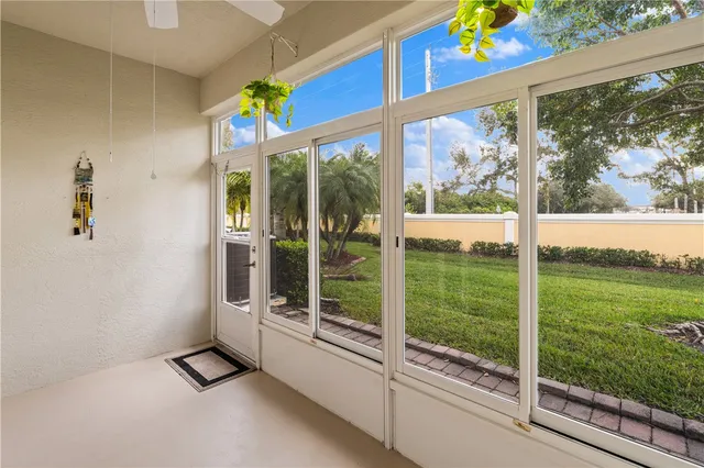 a view of a room with a large window and wooden floor