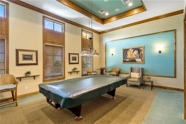 a room with pool table and windows