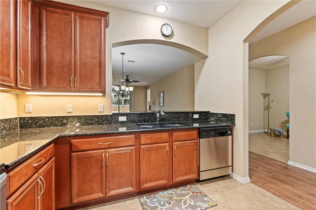 a kitchen with stainless steel appliances granite countertop a sink stove and cabinets