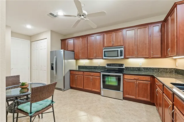 a kitchen with stainless steel appliances granite countertop wooden cabinets a stove top oven a sink and dishwasher