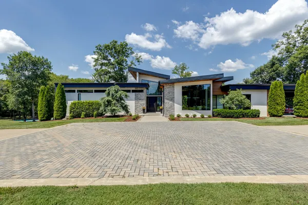 a front view of a house with a yard and potted plants