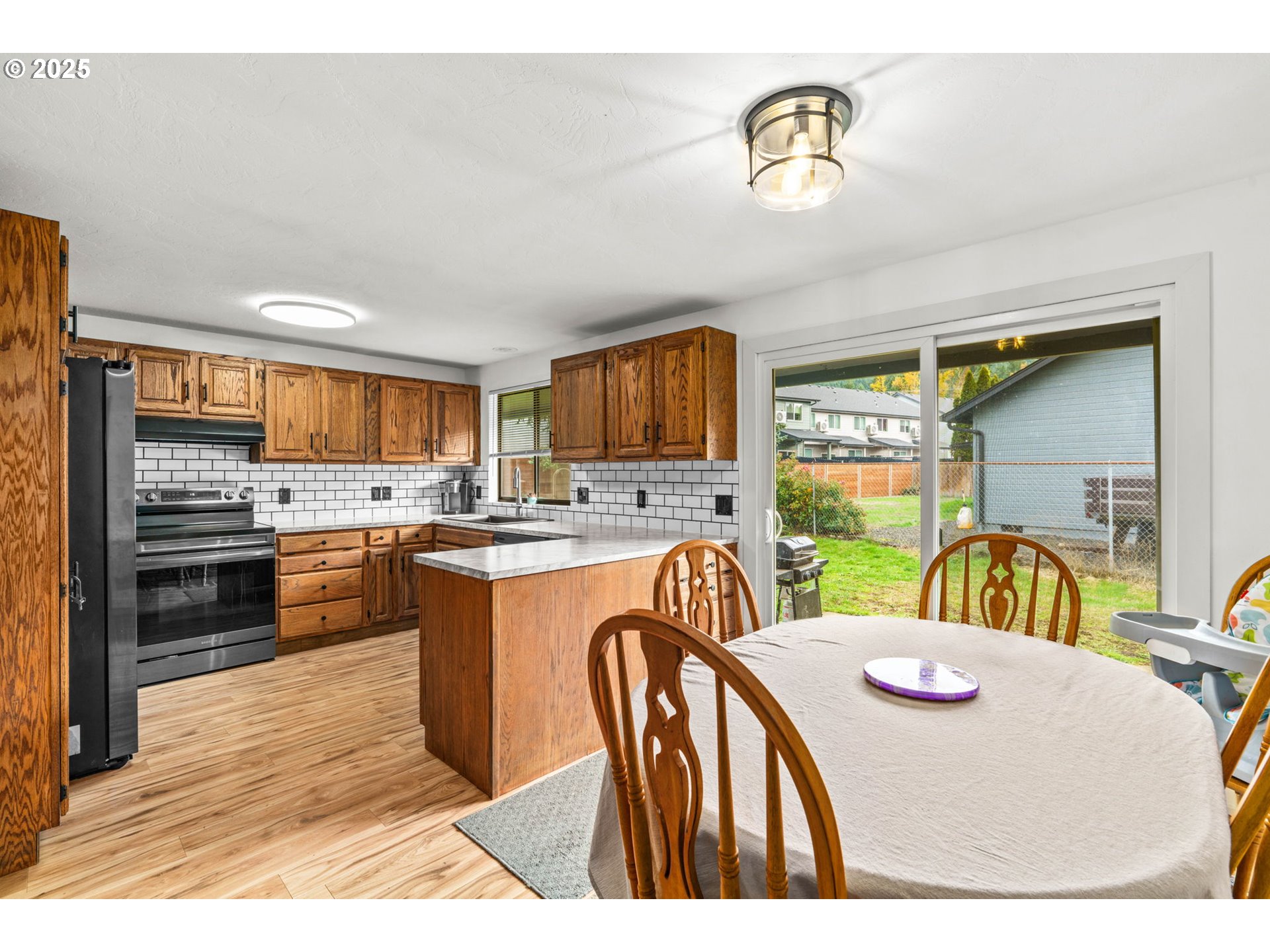 289 73rd Place Springfield, OR 97478 - Photo 11 of 32 a kitchen with stainless steel appliances granite countertop a sink a stove a dining table and chairs