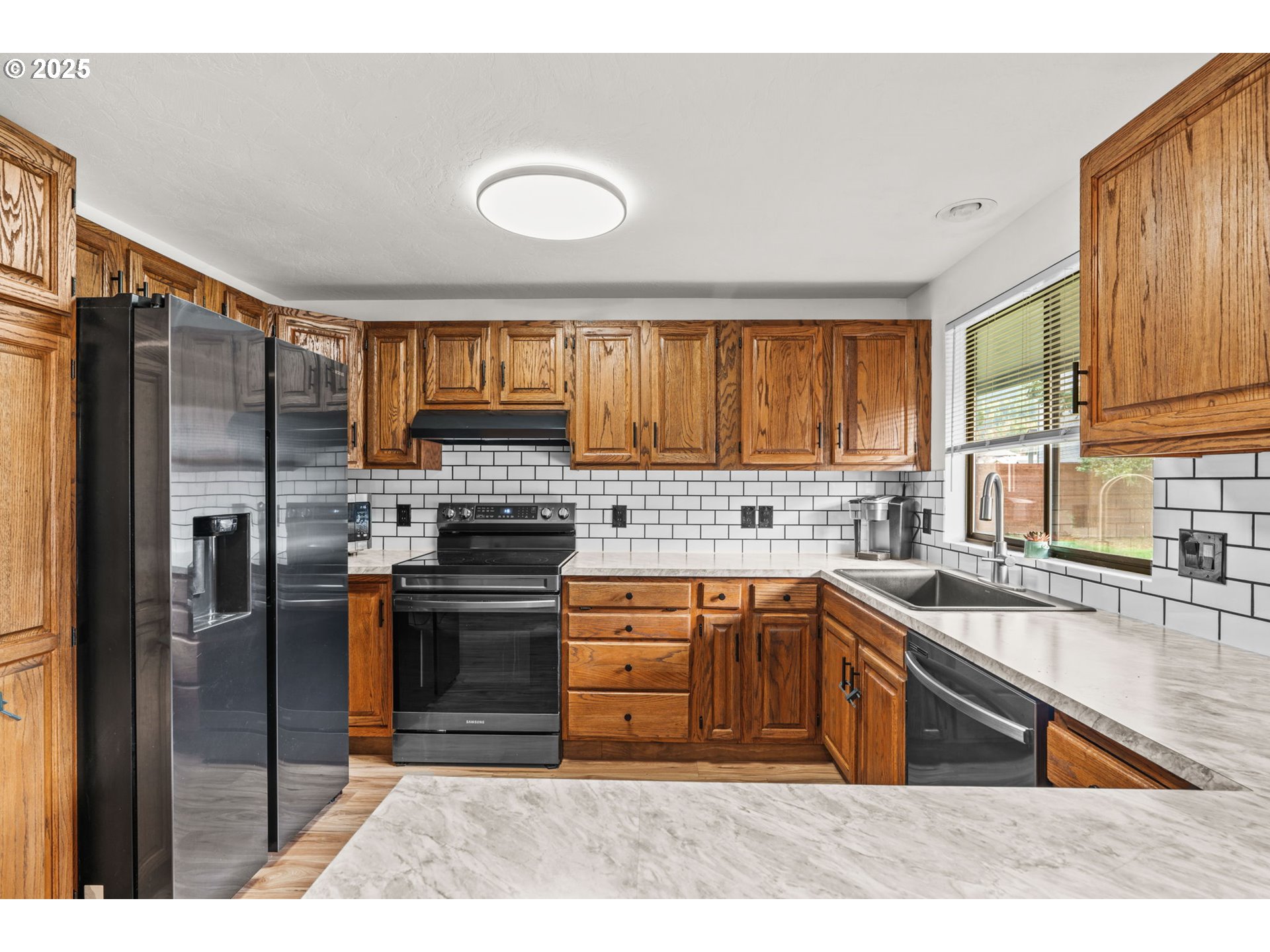 289 73rd Place Springfield, OR 97478 - Photo 14 of 32 a kitchen with stainless steel appliances granite countertop a stove a sink dishwasher a refrigerator and cabinets with wooden floor