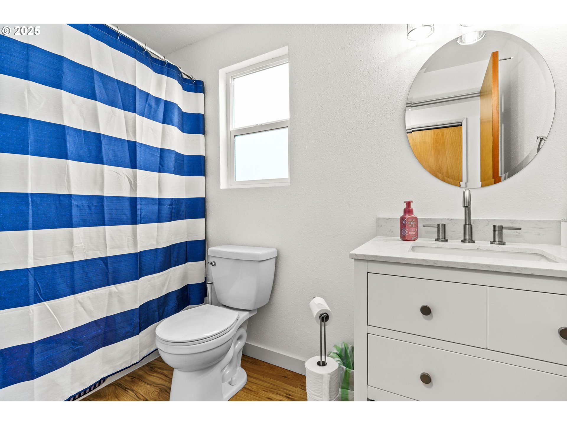 289 73rd Place Springfield, OR 97478 - Photo 21 of 32 a bathroom with a sink a mirror a toilet and a window
