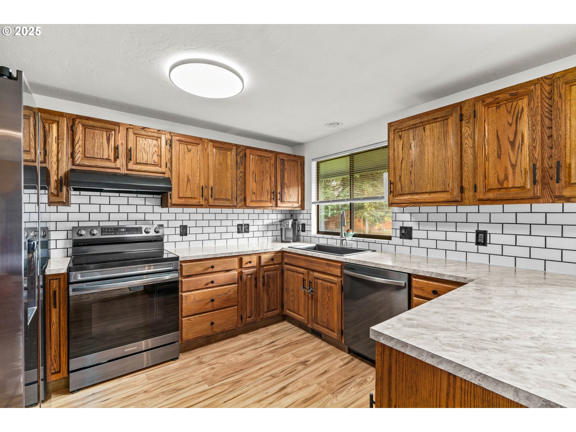 289 73rd Place Springfield, OR 97478 - Photo 10 of 32 a kitchen with stainless steel appliances granite countertop a sink stove and oven
