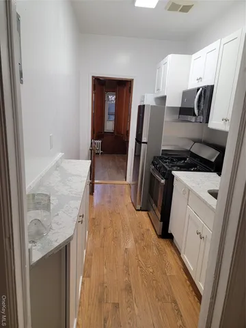 a kitchen with a refrigerator a stove top oven and cabinets