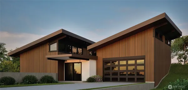 a front view of a house with glass windows and plants
