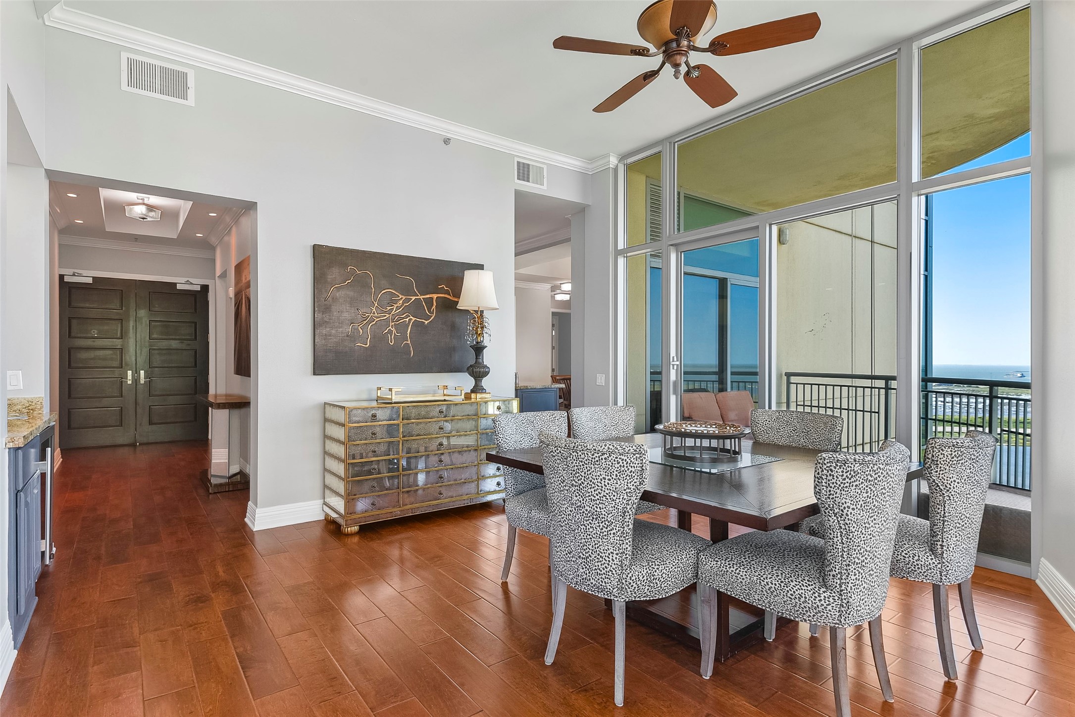 801 East Beach Drive, Unit TW2704 Galveston, TX 77550 - Photo 10 of 48 a dining room with wooden floor a chandelier a glass table and chairs