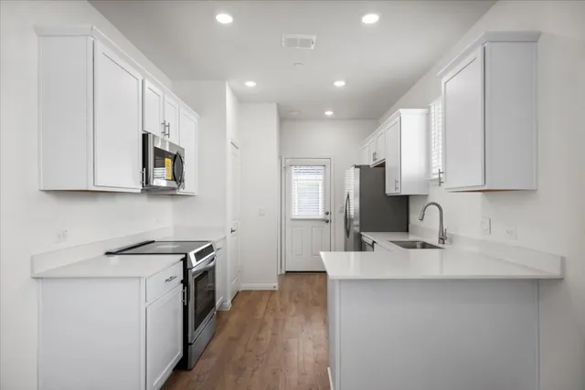a kitchen with kitchen island a sink stainless steel appliances and cabinets