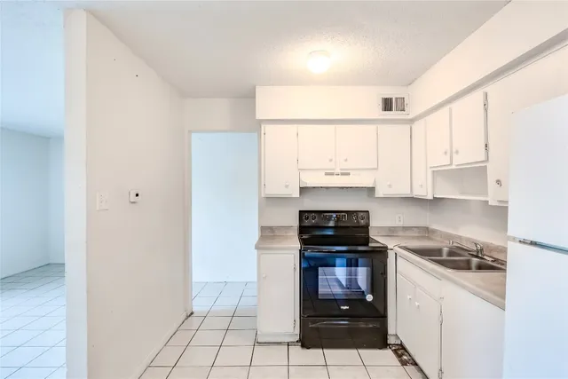 a kitchen with a stove a sink and a refrigerator