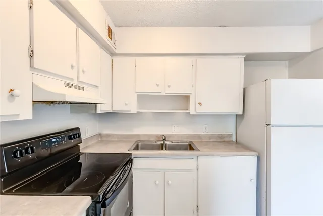 a kitchen with a white cabinets and white appliances