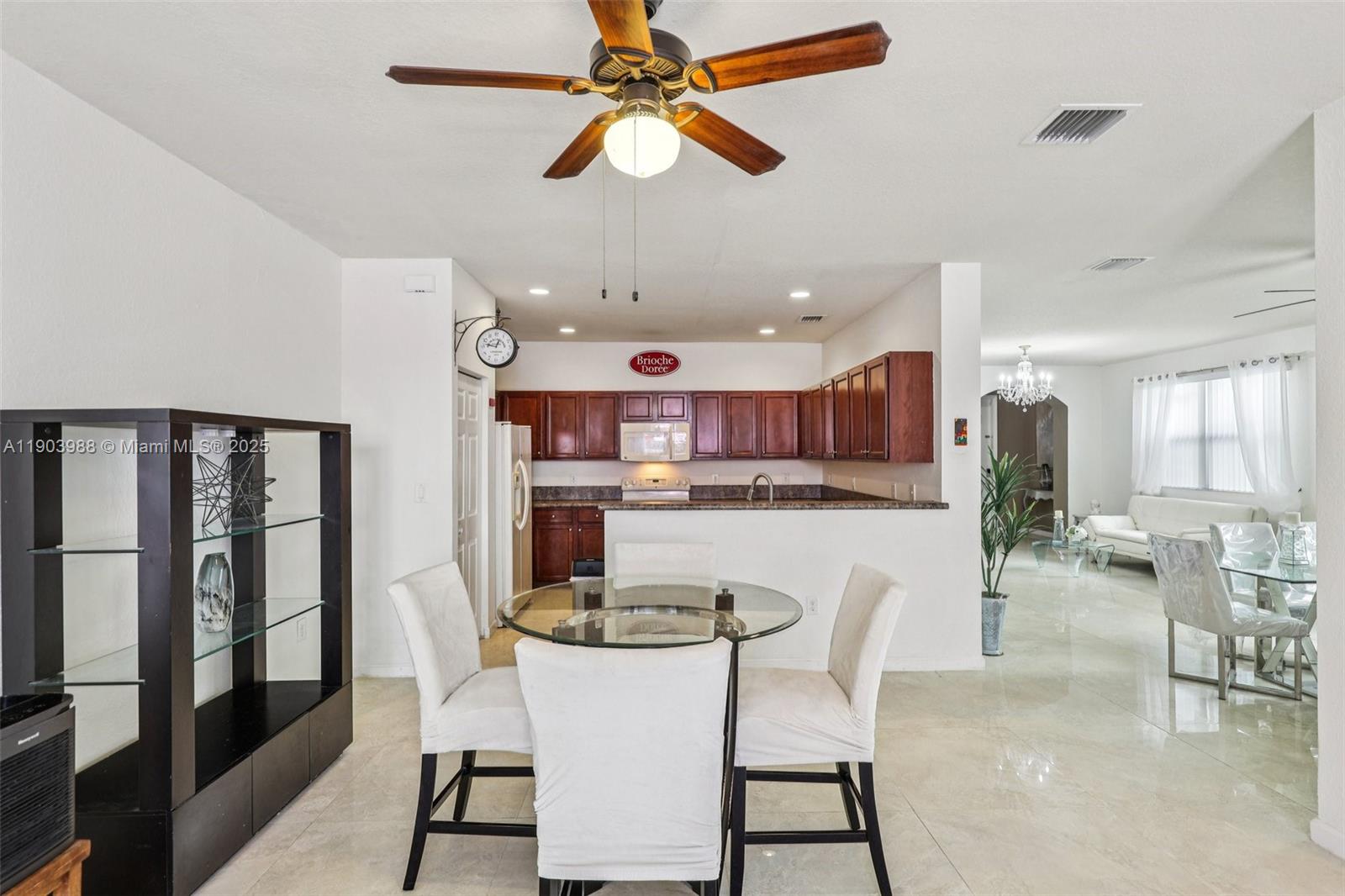 22777 Southwest 93rd Court Cutler Bay, FL 33190 - Photo 13 of 54 a kitchen with stainless steel appliances kitchen island granite countertop a dining table chairs and view living room