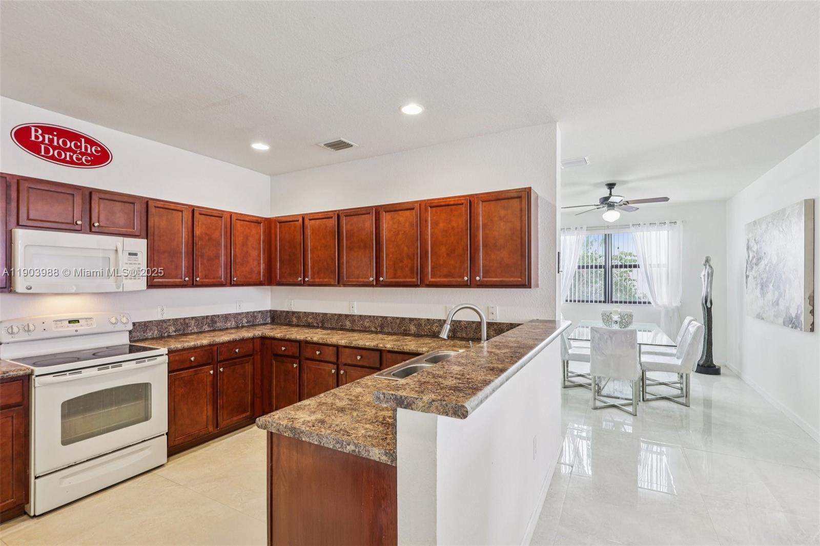 22777 Southwest 93rd Court Cutler Bay, FL 33190 - Photo 15 of 54 a kitchen with a sink stove and cabinets