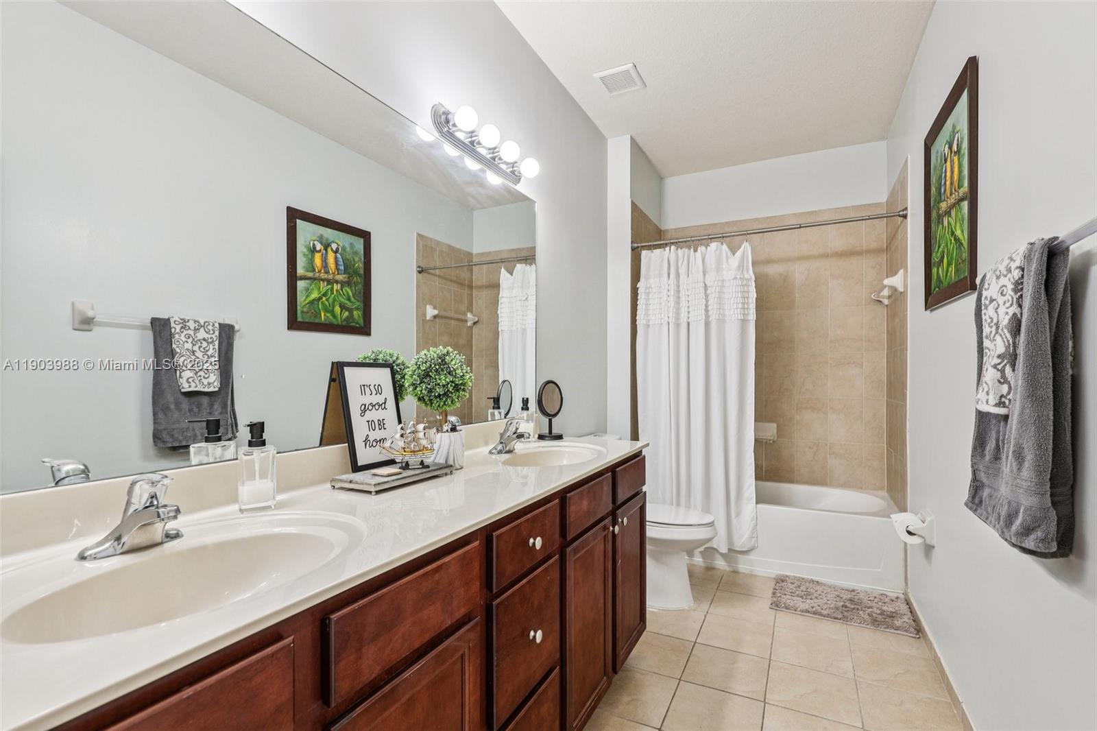 22777 Southwest 93rd Court Cutler Bay, FL 33190 - Photo 32 of 54 a bathroom with a double vanity sink a large mirror a bathtub and shower