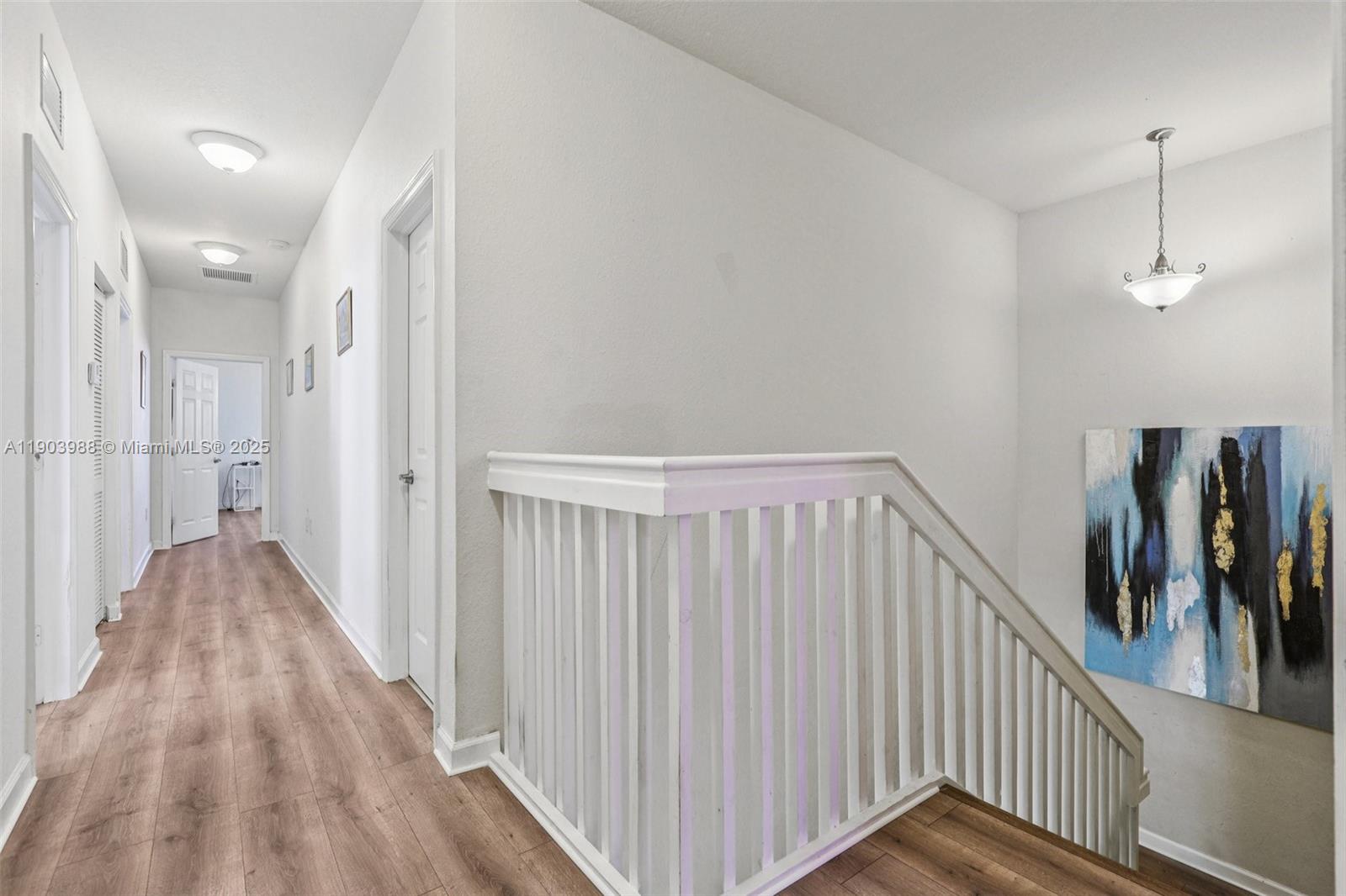 22777 Southwest 93rd Court Cutler Bay, FL 33190 - Photo 40 of 54 a view of a hallway with wooden floor and stairs