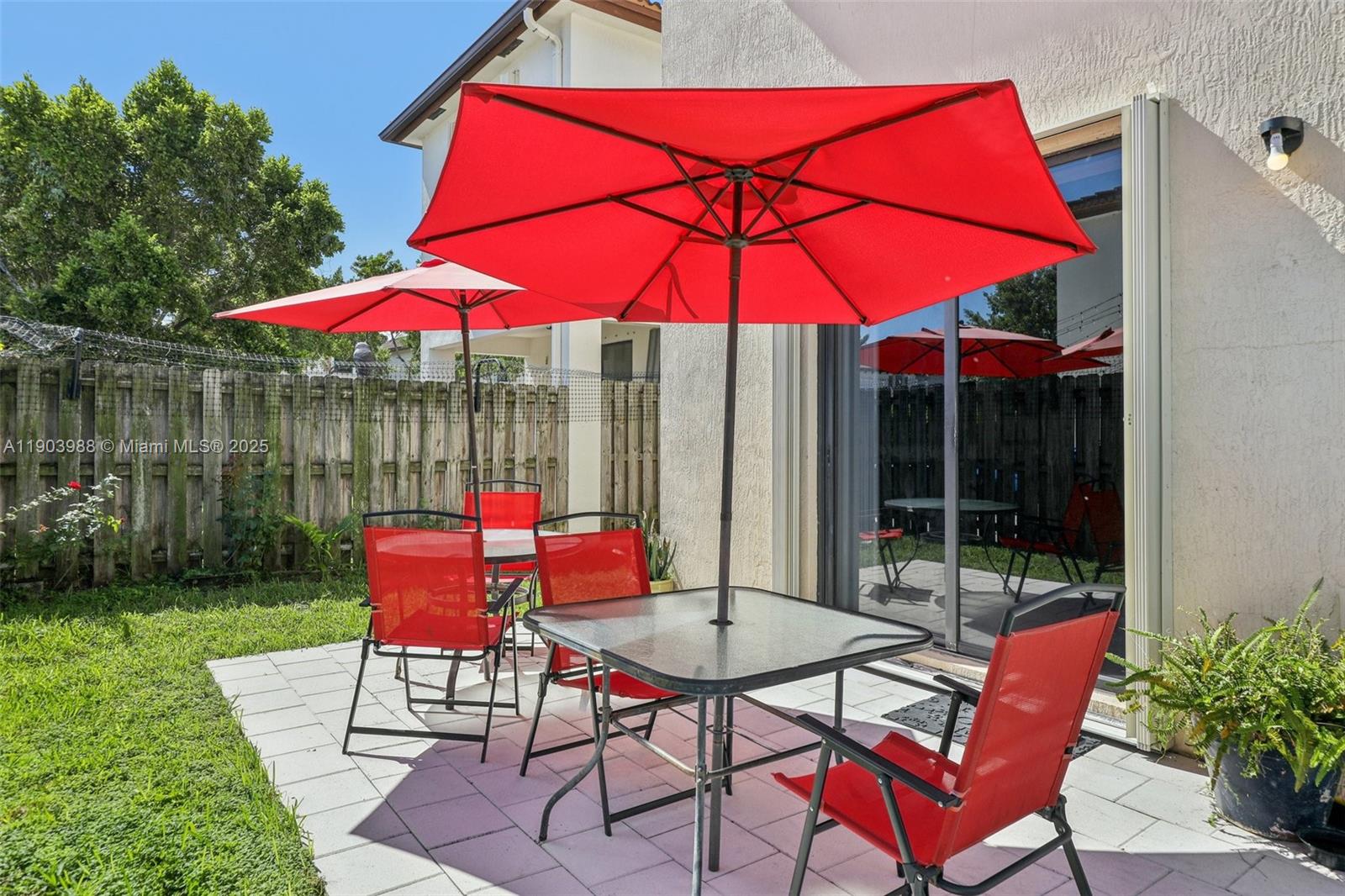 22777 Southwest 93rd Court Cutler Bay, FL 33190 - Photo 45 of 54 a patio with a table and chairs under an umbrella