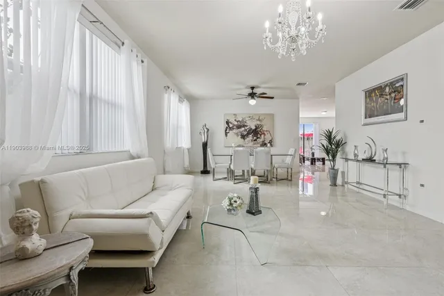 a living room with furniture a flat screen tv and a window
