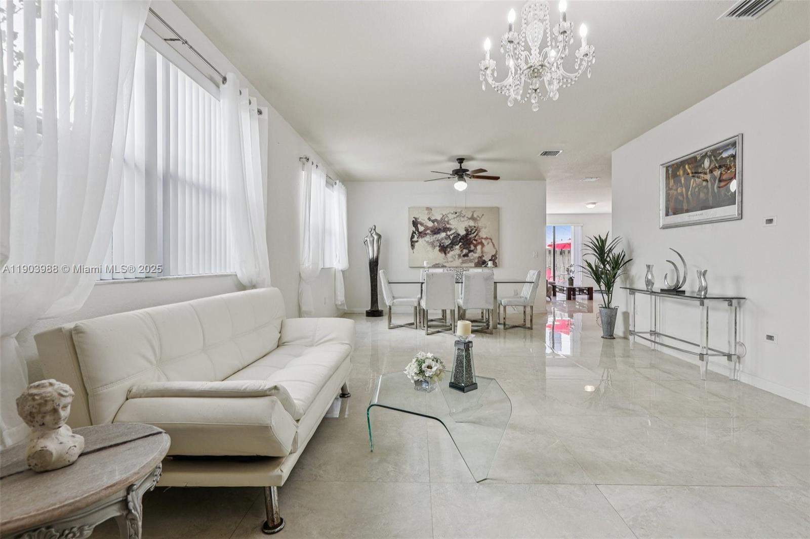 22777 Southwest 93rd Court Cutler Bay, FL 33190 - Photo 6 of 54 a living room with patio furniture and a chandelier