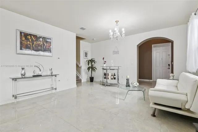 a living room with furniture and a chandelier