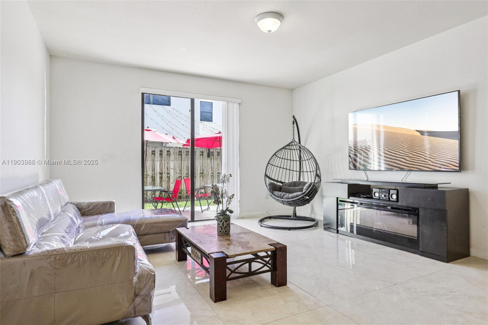 22777 Southwest 93rd Court Cutler Bay, FL 33190 - Photo 8 of 54 a living room with furniture a flat screen tv and a window