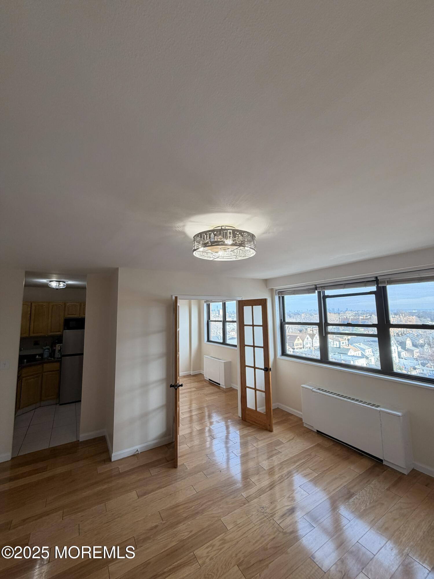 1225 John F. Kennedy Boulevard, Unit 8I Bayonne, NJ 07002 - Photo 7 of 18 wooden floor in an empty room with a window