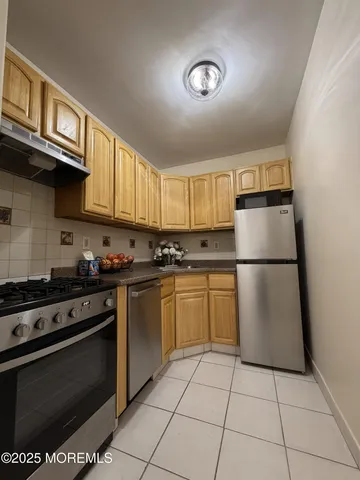 a kitchen with a stove top oven cabinets and a refrigerator