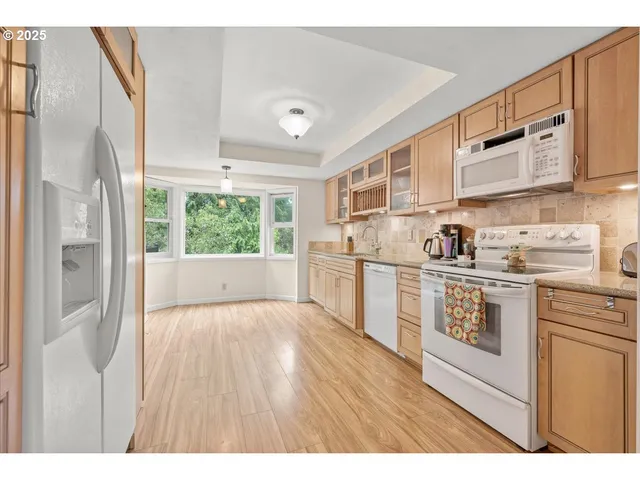 a kitchen with white cabinets and white appliances