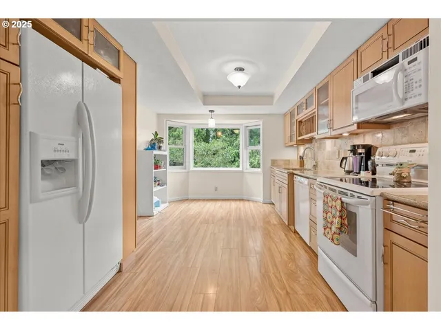 a open kitchen with cabinets and wooden floor