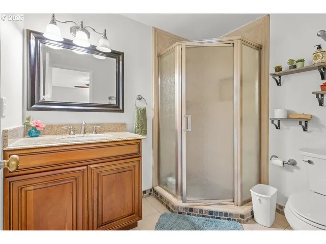 a bathroom with a granite countertop sink a toilet and a mirror