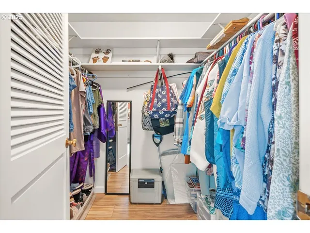 a view of a walk in closet with clothes