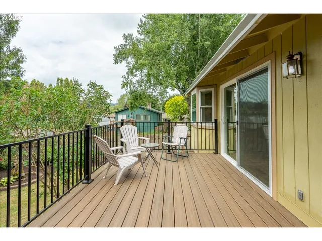 a balcony with wooden floor table and chairs